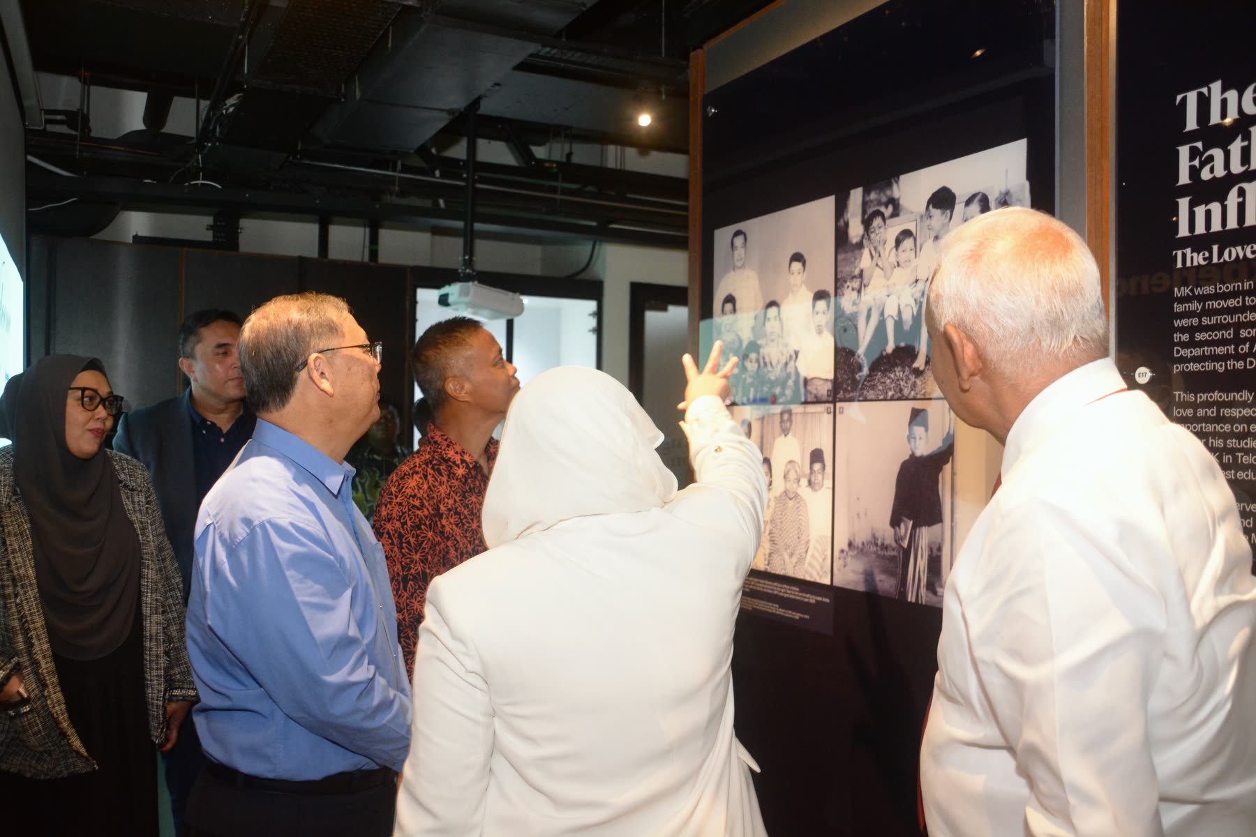 Guests viewing the Yayasan EMKAY anniversary exhibition wall