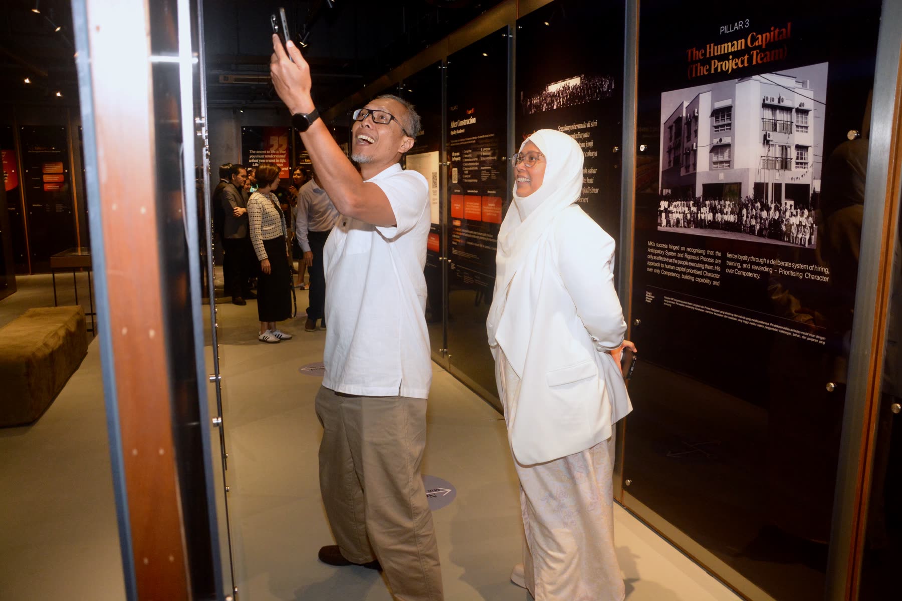 Two guests sharing a candid moment at the Yayasan EMKAY anniversary